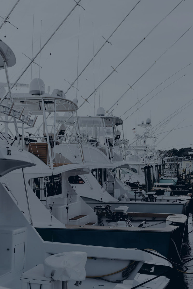 Sportfishing boats with tuna towers and antennas moored along a dock